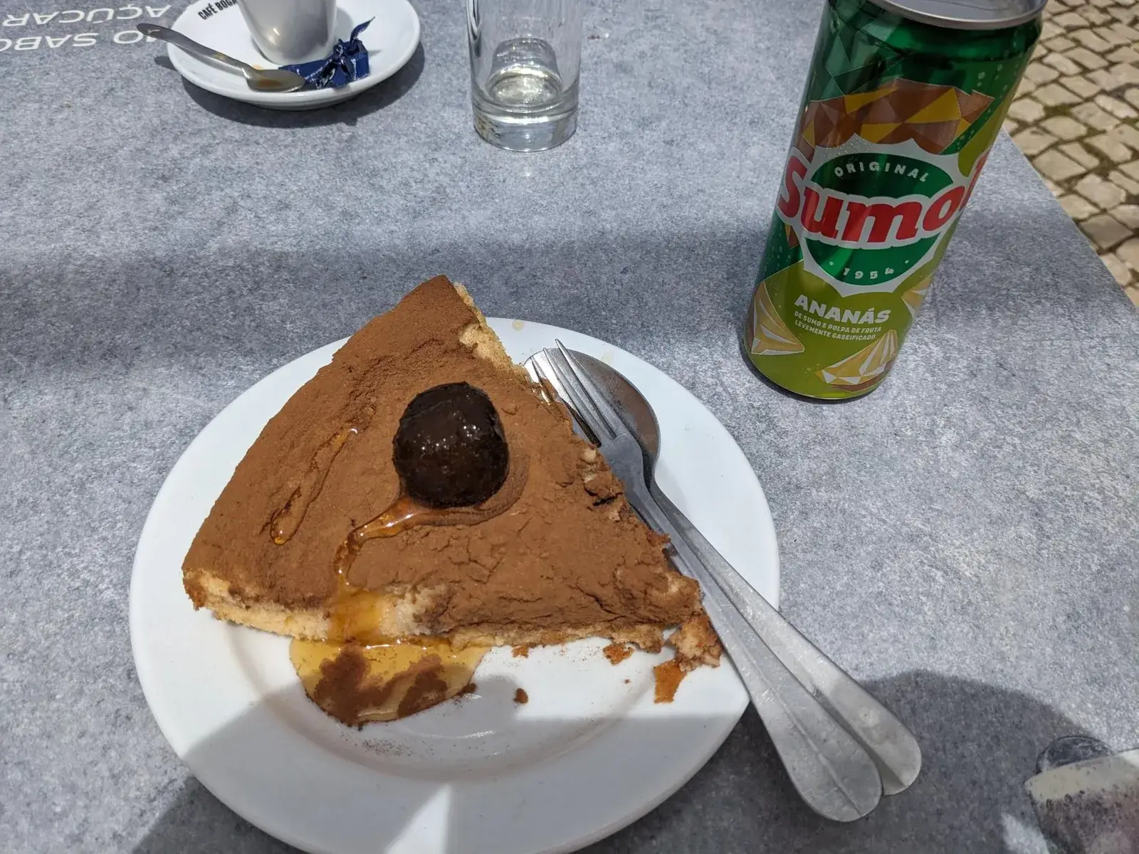 A slice of chocolate cake and a soft drink at a café