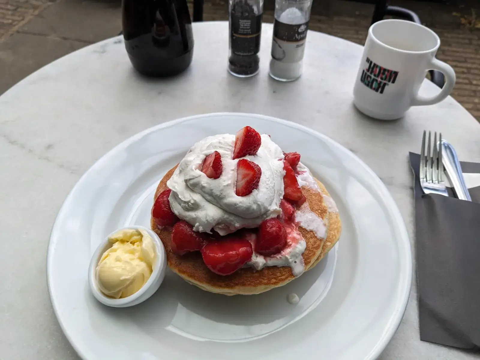 A strawberry pancake with cream and ice cream