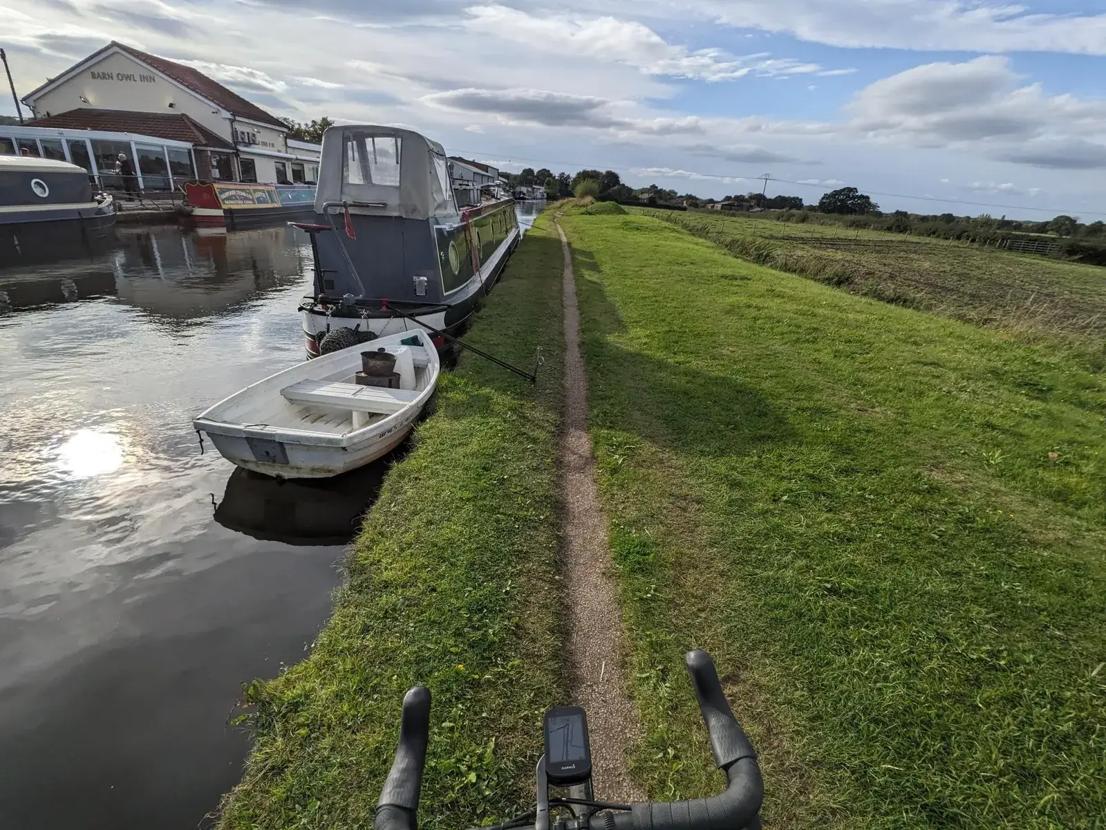 Small boats moored beside a grassy canal path