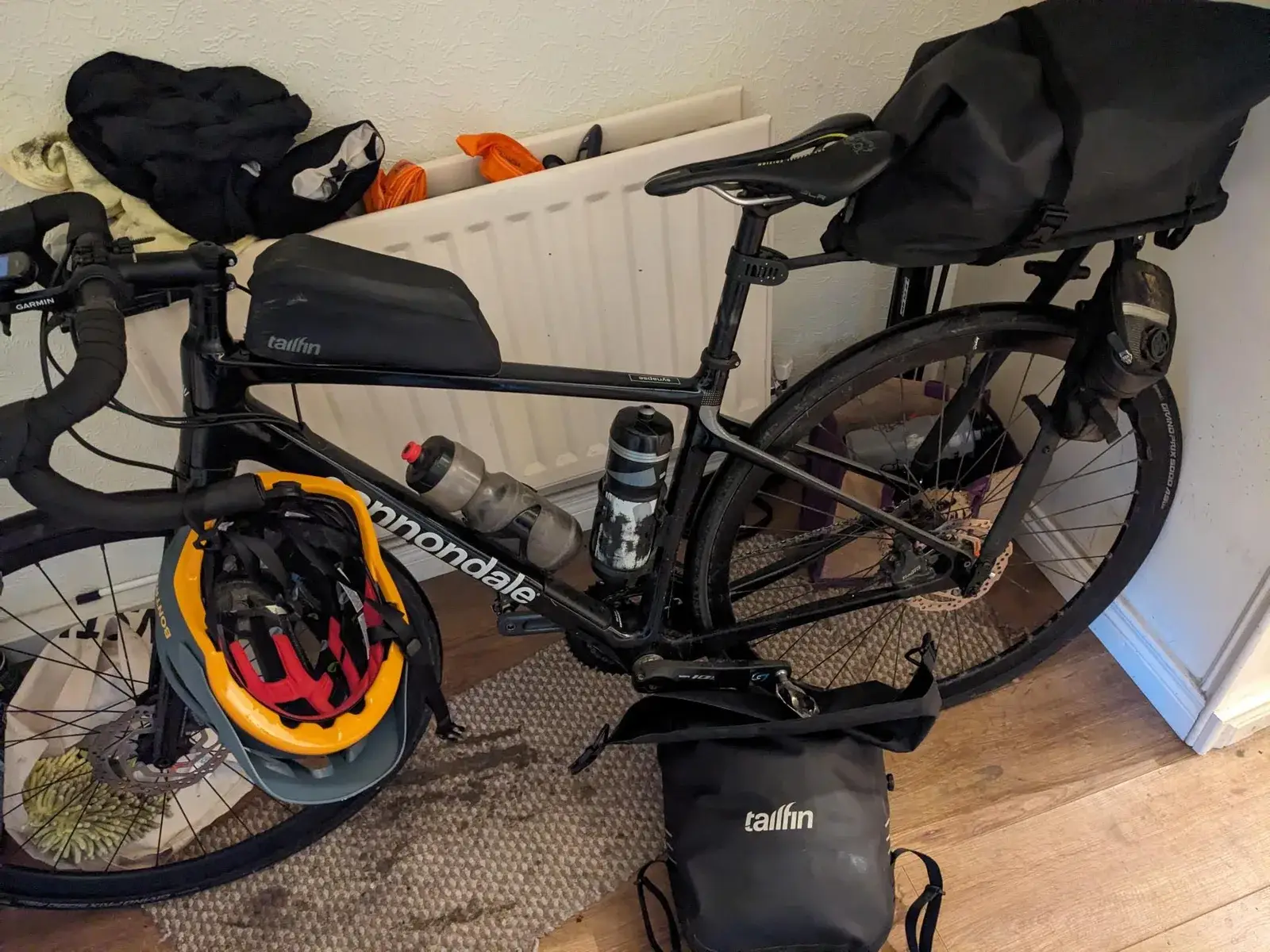 A loaded touring bicycle and helmet indoors after the trip