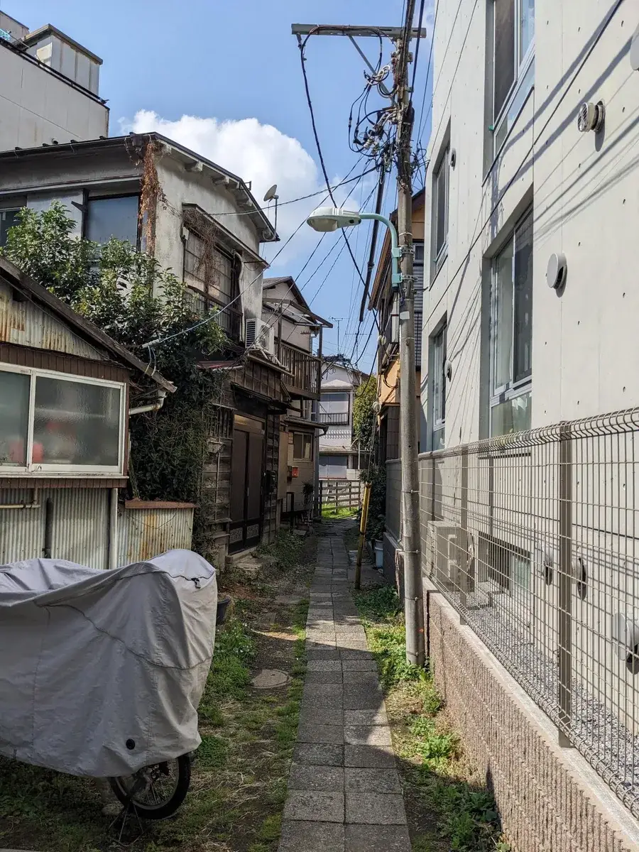 A narrow residential street between closely packed Japanese houses