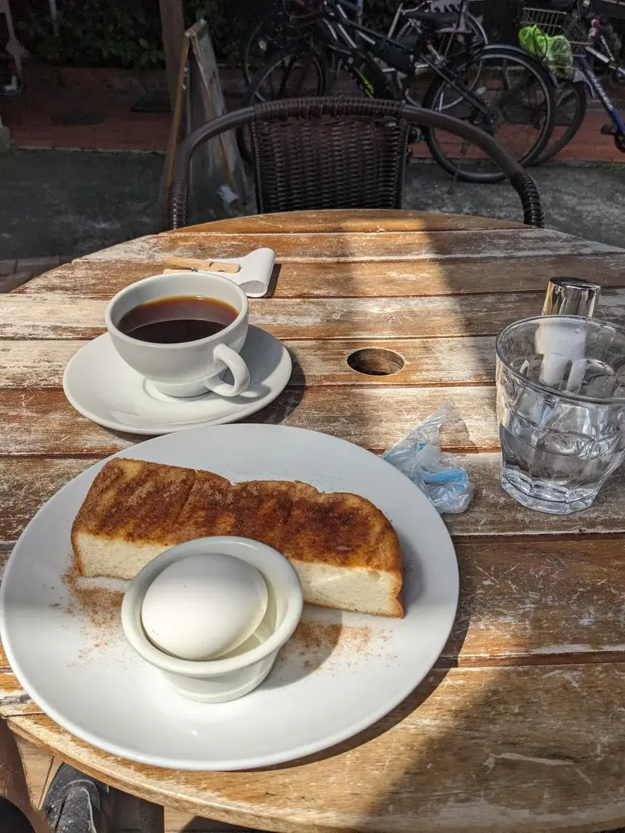 Coffee and thick toast on a sunlit wooden table