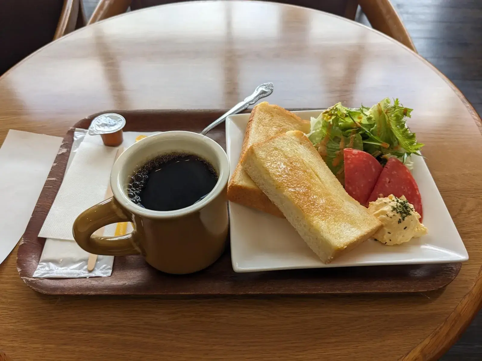 Coffee, toast, salad and fruit on a café tray