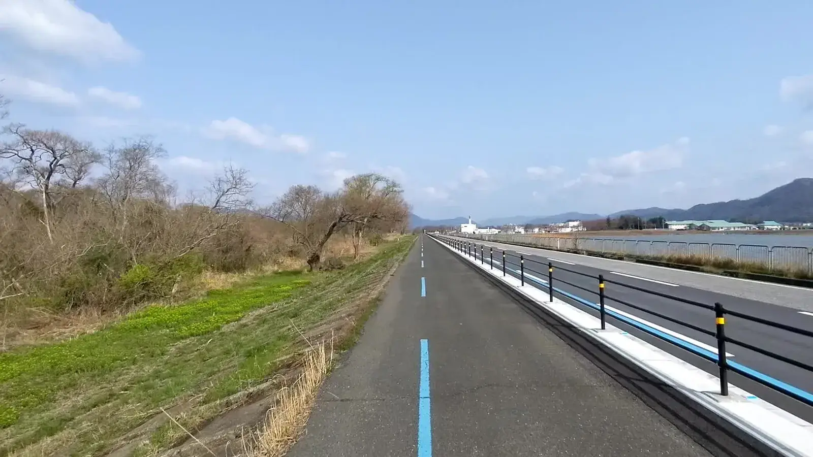 A blue cycle lane beside a quiet highway
