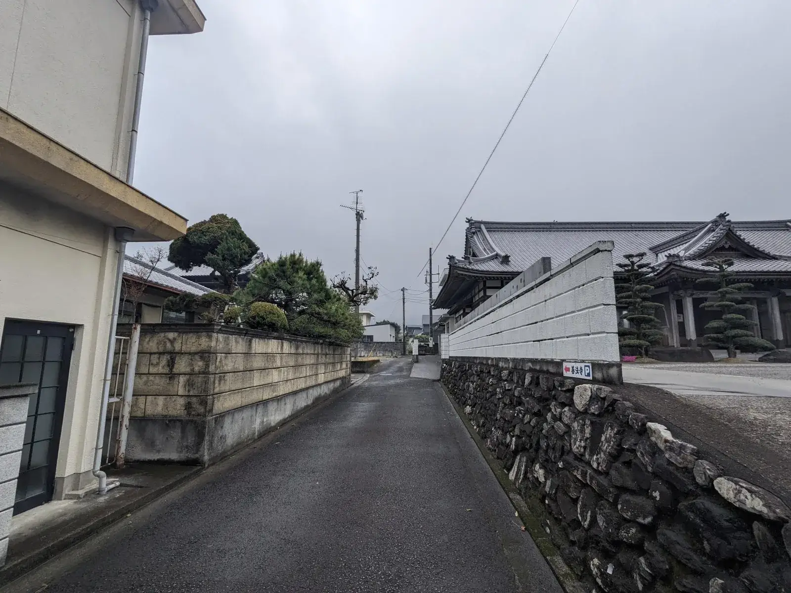 A narrow residential street lined with traditional walls