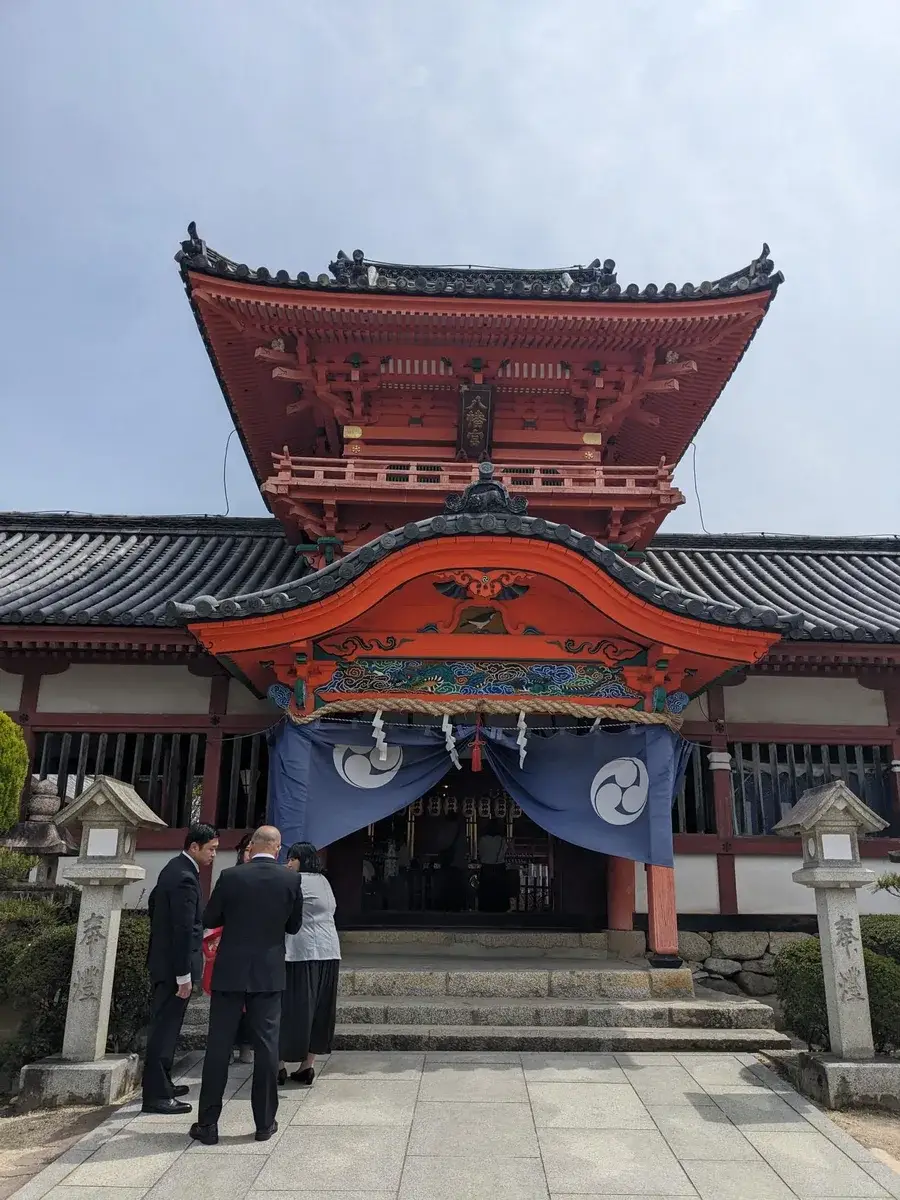 An ornate red temple gate viewed from its courtyard