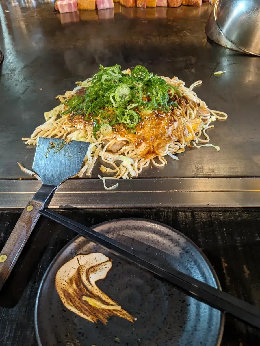 Okonomiyaki cooking on a hotplate