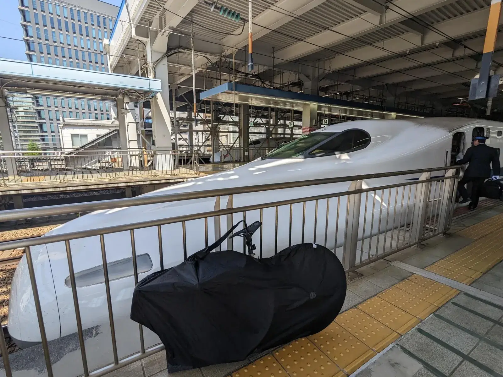 A Shinkansen train waiting beside a touring bicycle at the station