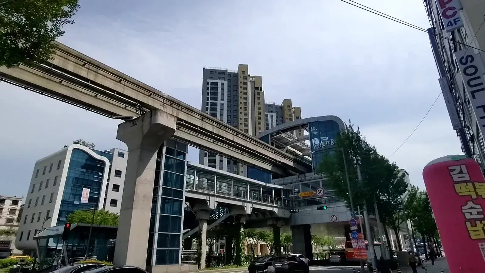 An elevated monorail running through a Korean city street