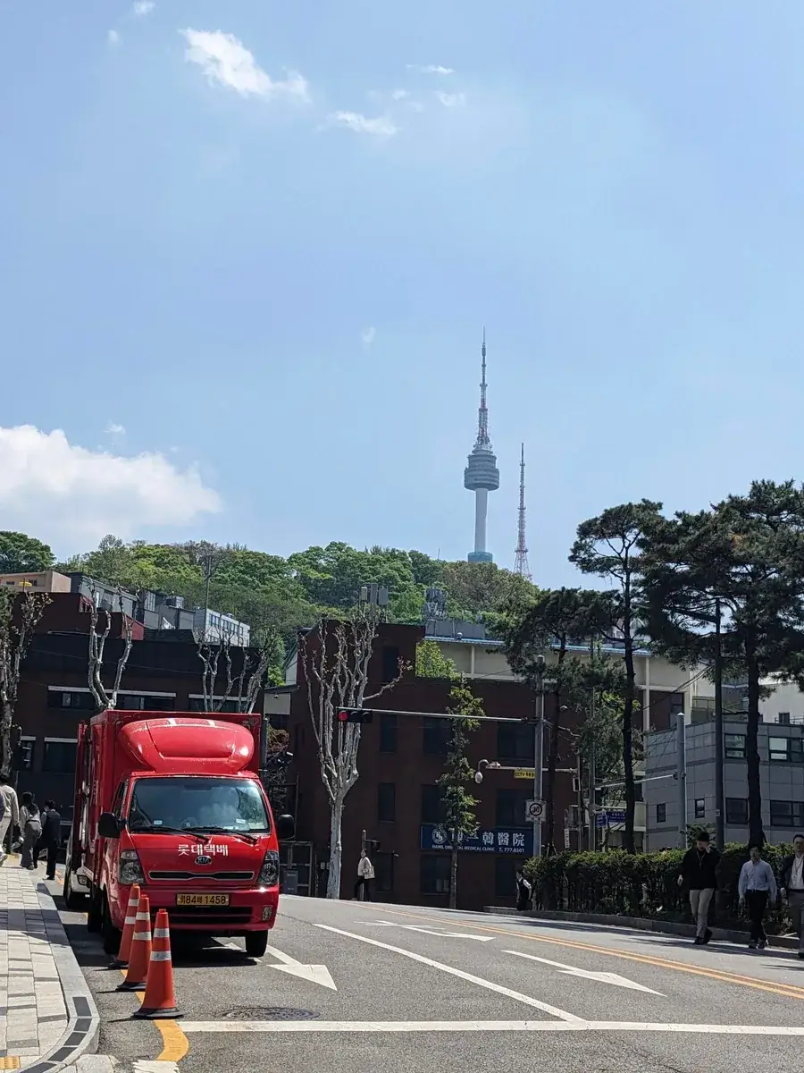 N Seoul Tower rising above trees and city rooftops
