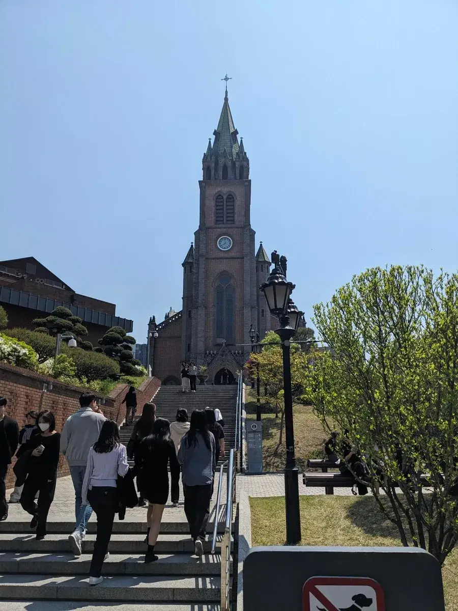 A brick cathedral with a tall central bell tower