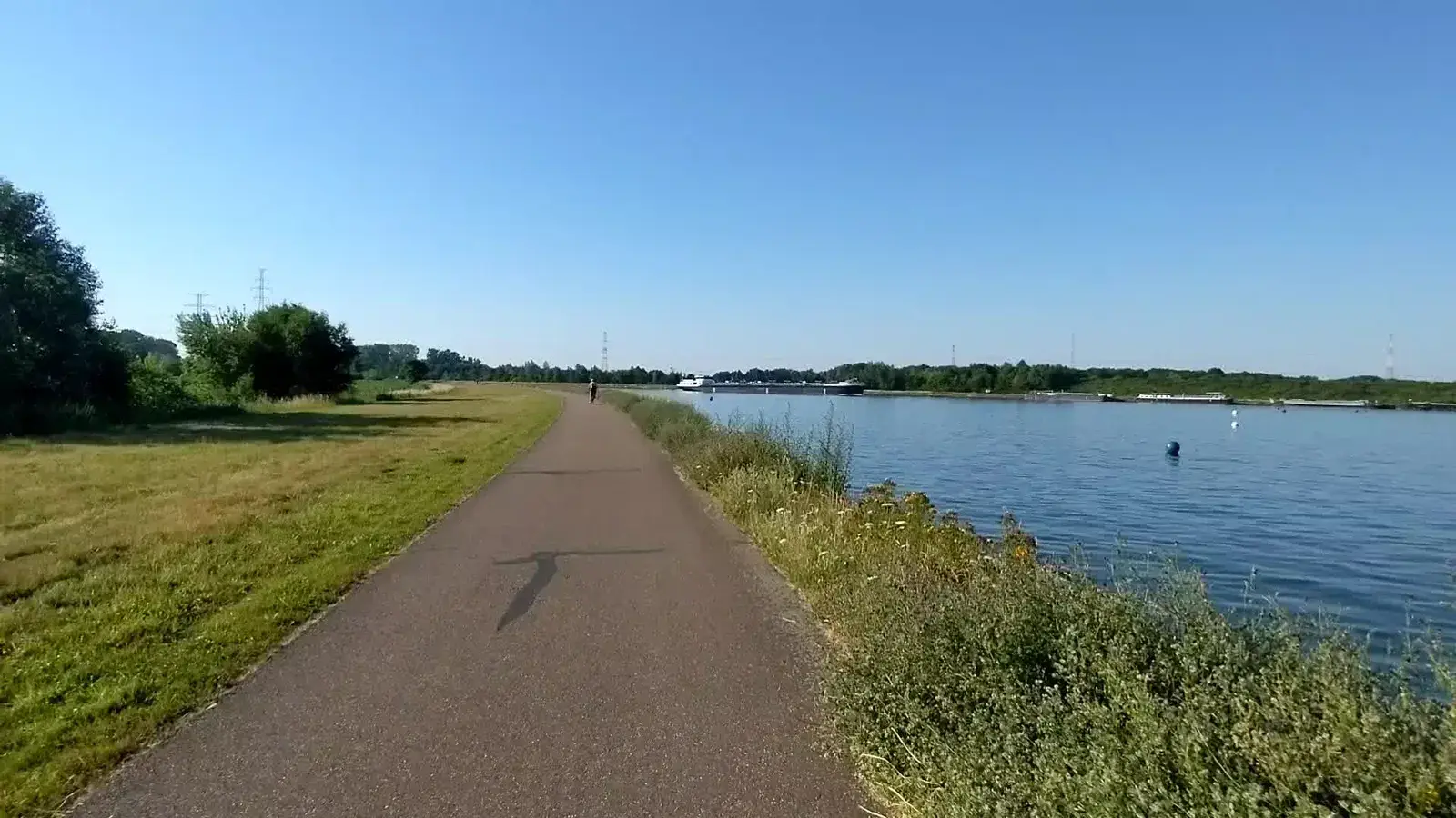 A waterside cycle path on a clear summer day