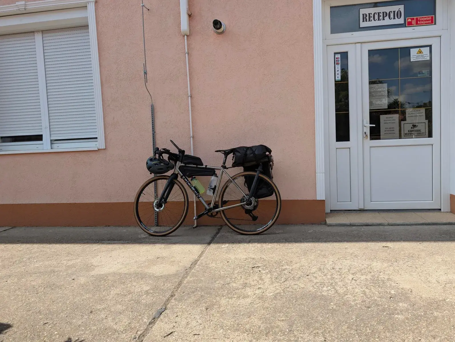 A loaded touring bicycle outside a small reception