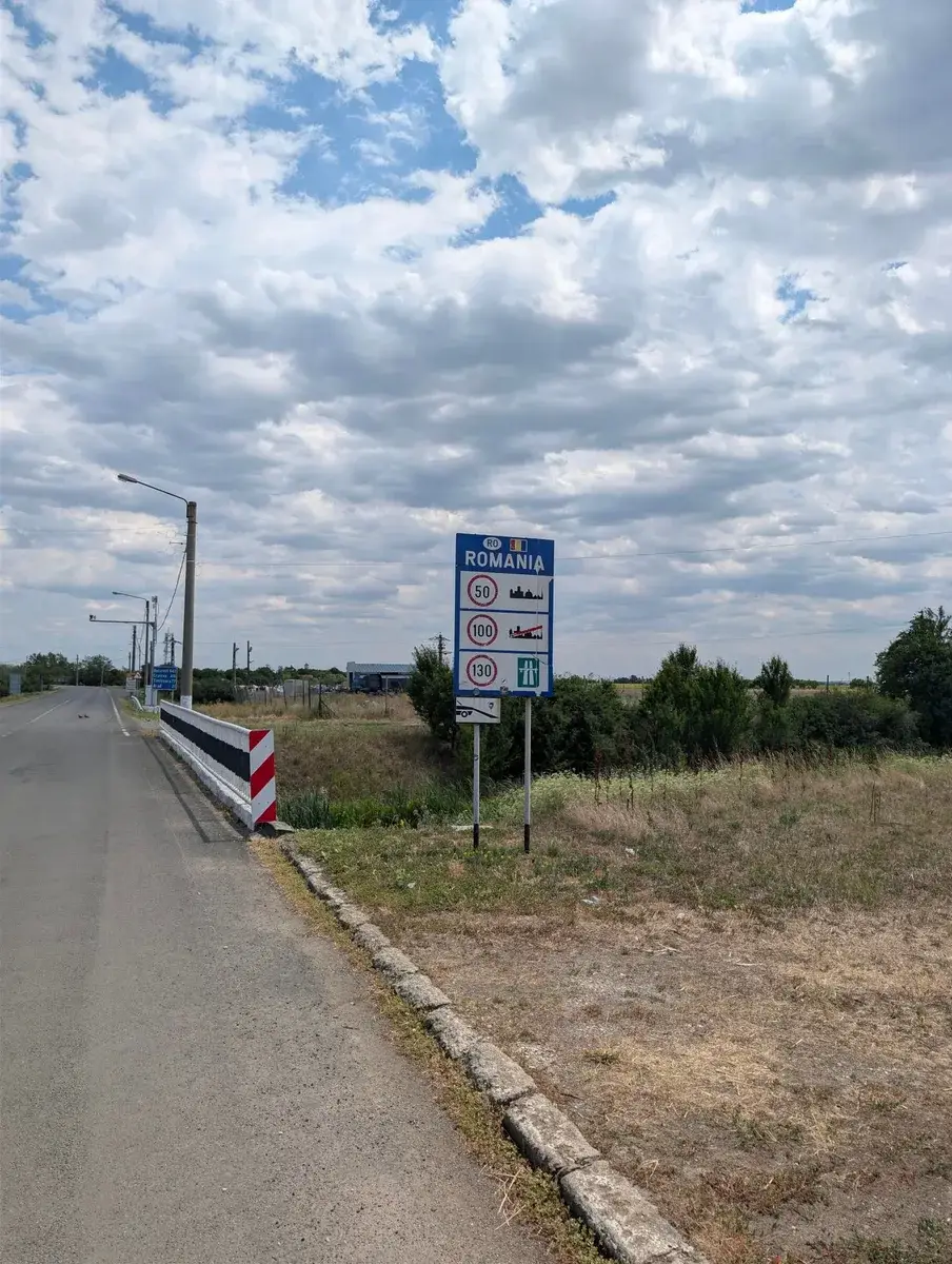 A Romania border sign beside a quiet road
