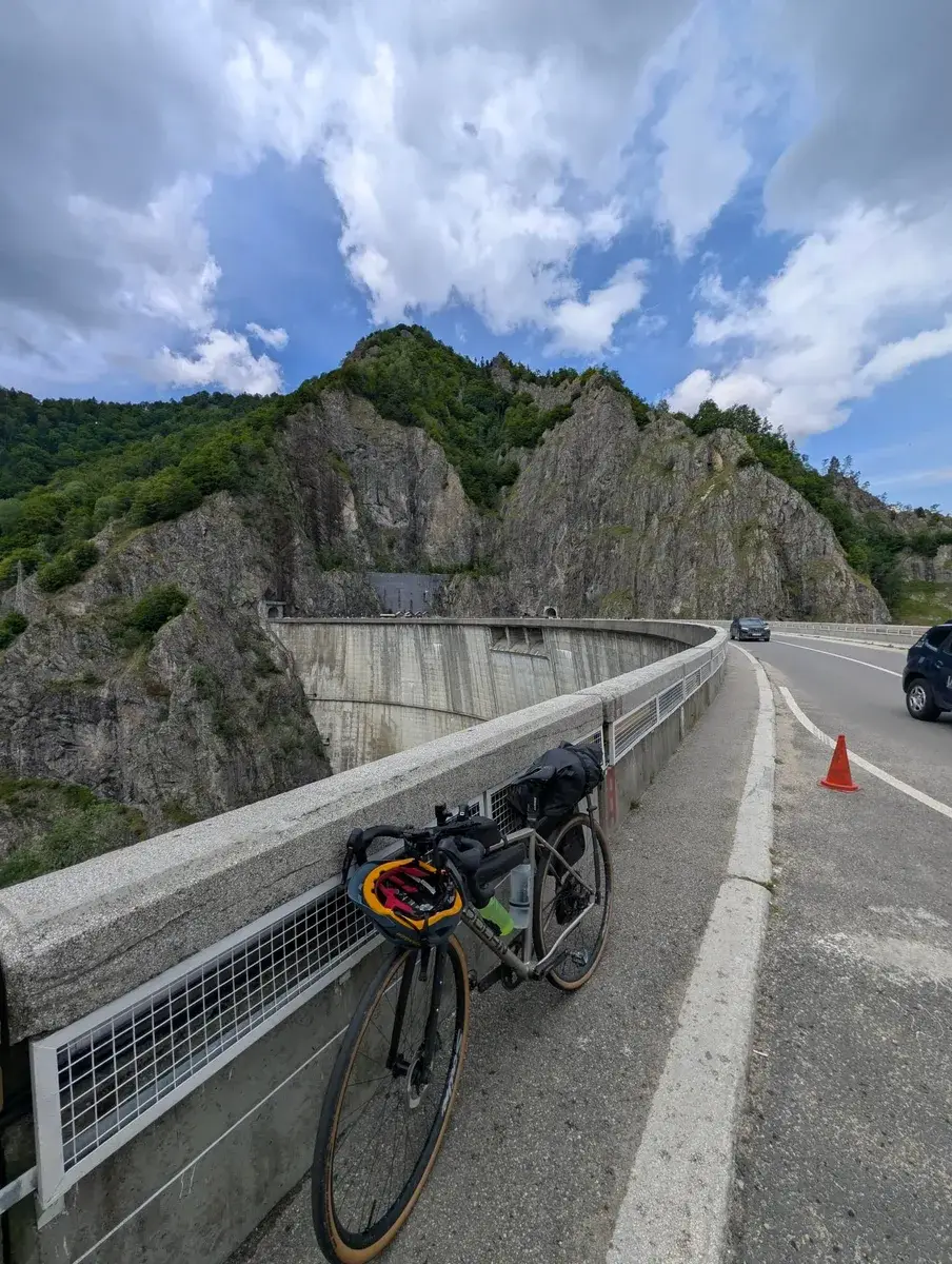 A touring bicycle beside a road cut through steep rock