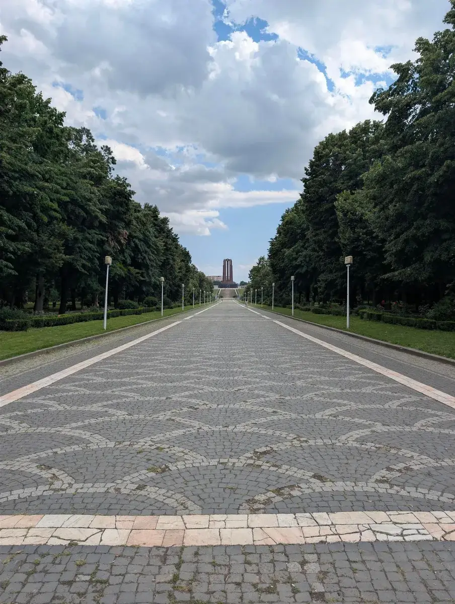 A long tree-lined avenue leading towards a tower
