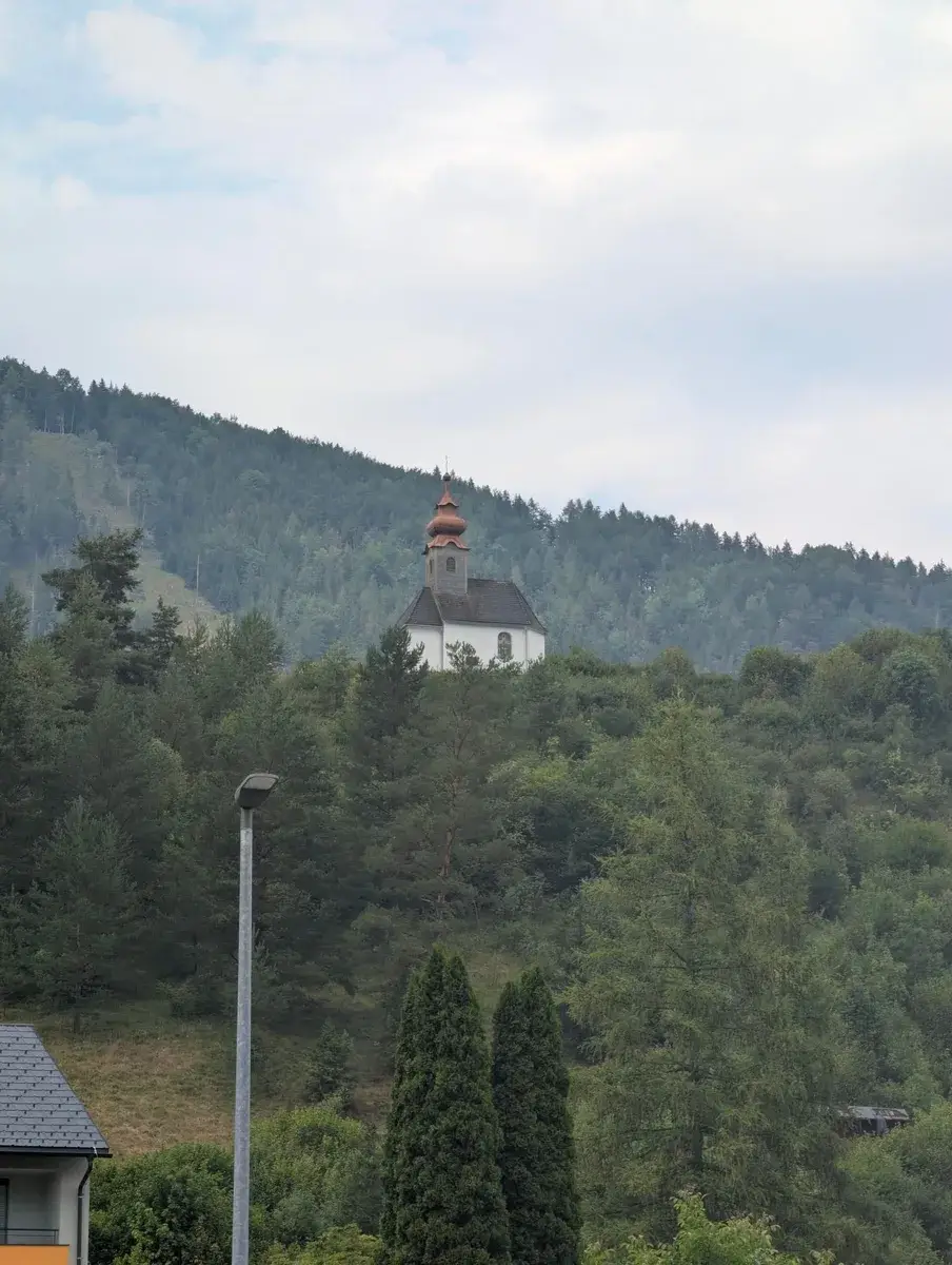 A small church on a wooded alpine hillside