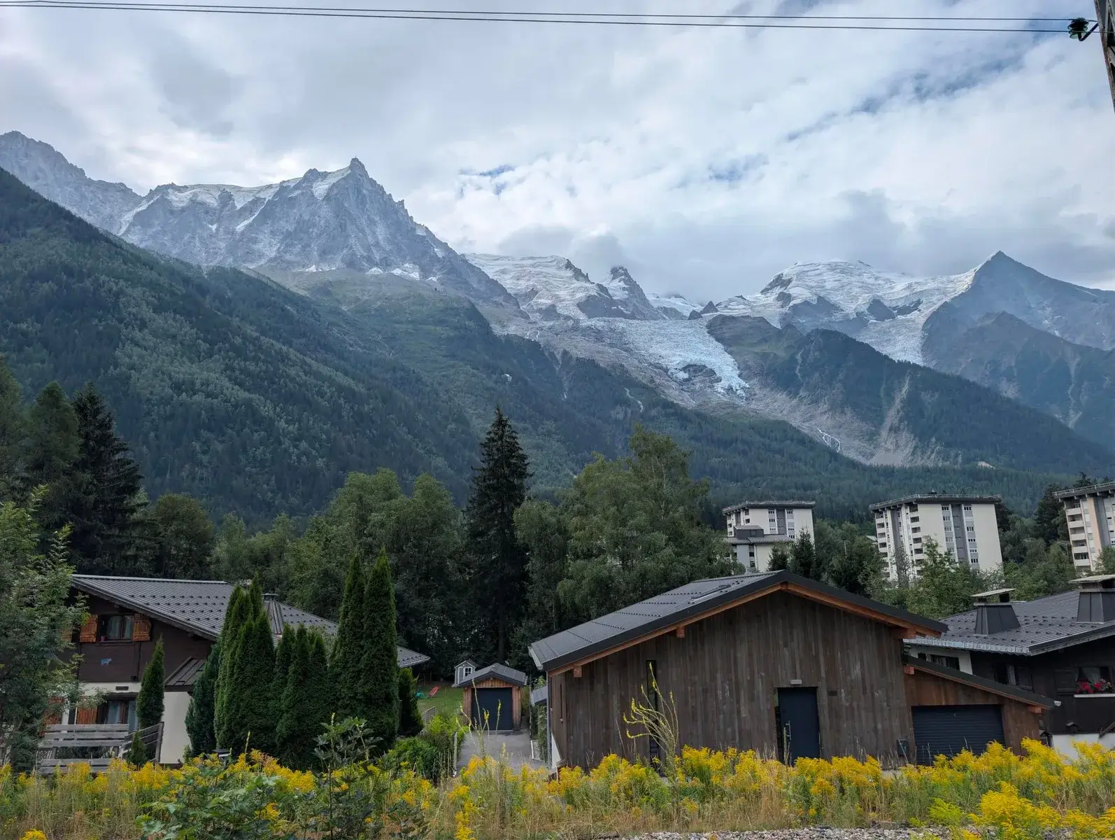 A mountain town beneath steep cloud-covered peaks