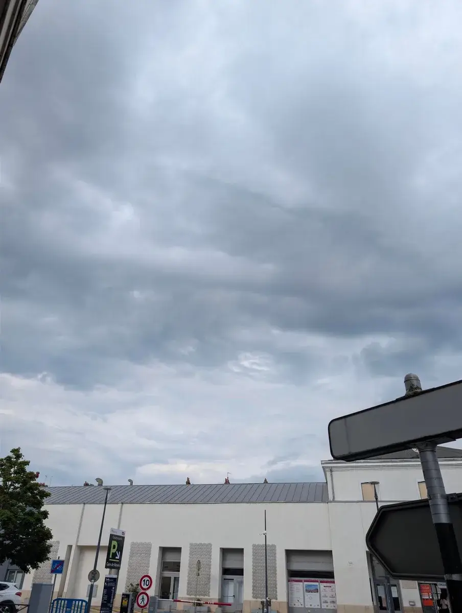 Dark storm clouds gathering above a roofline