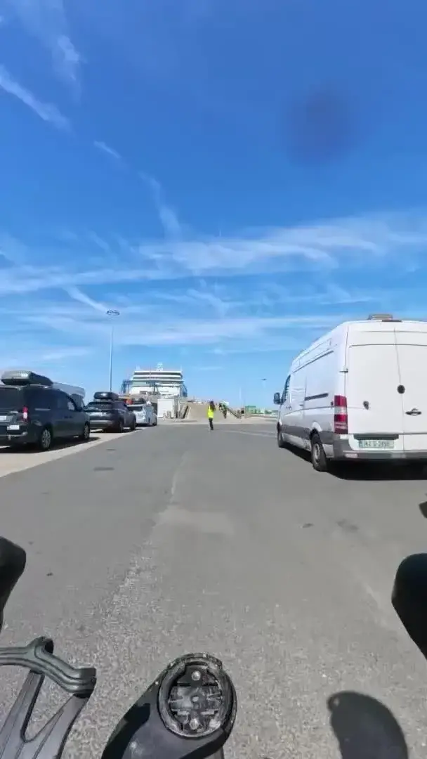 Vehicles waiting to board a ferry under blue sky