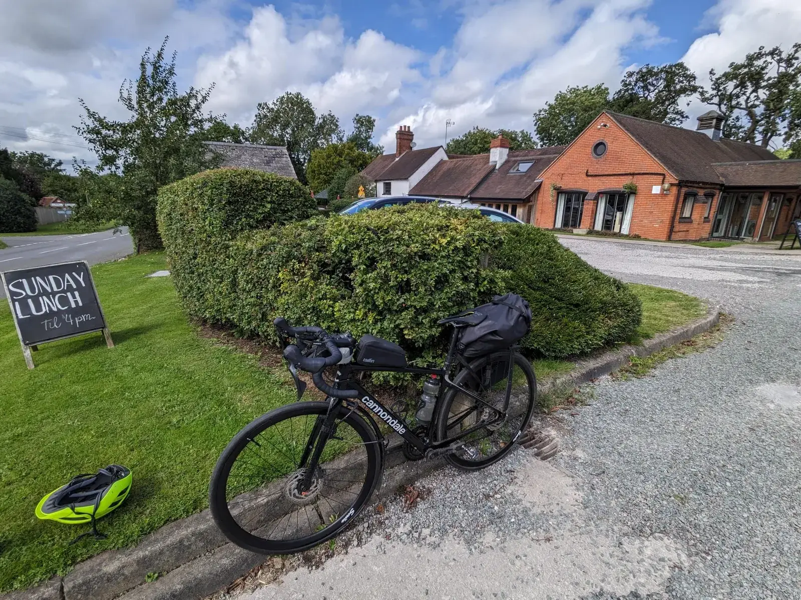 A loaded touring bicycle outside a red-roofed country lodge