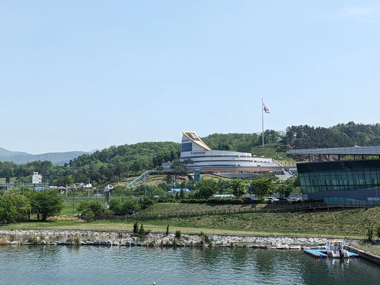 A striking angular white building on the waterfront, with boats moored nearby