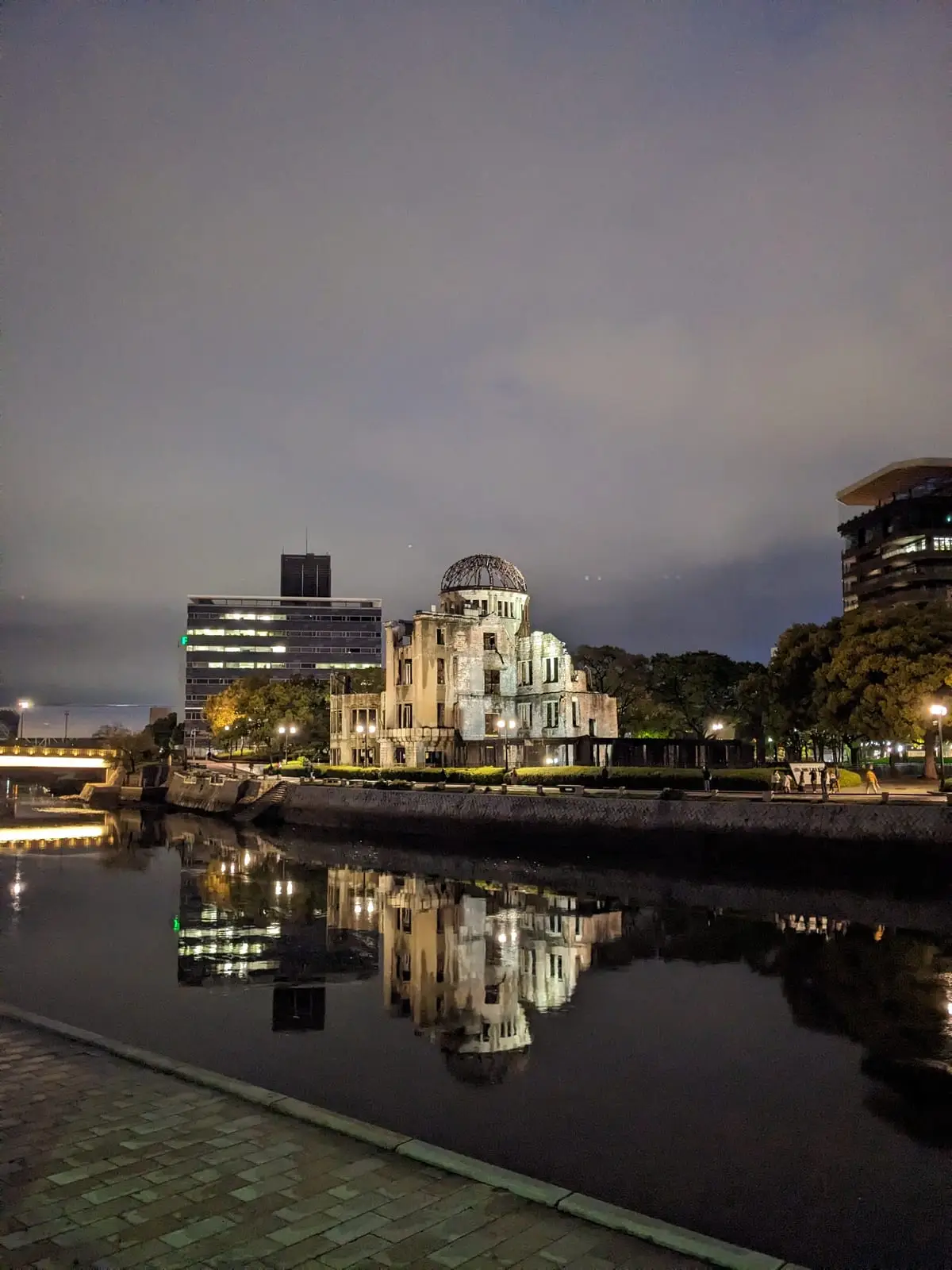 The Hiroshima Peace Memorial (Atomic Bomb Dome) illuminated at dusk, reflected in the river