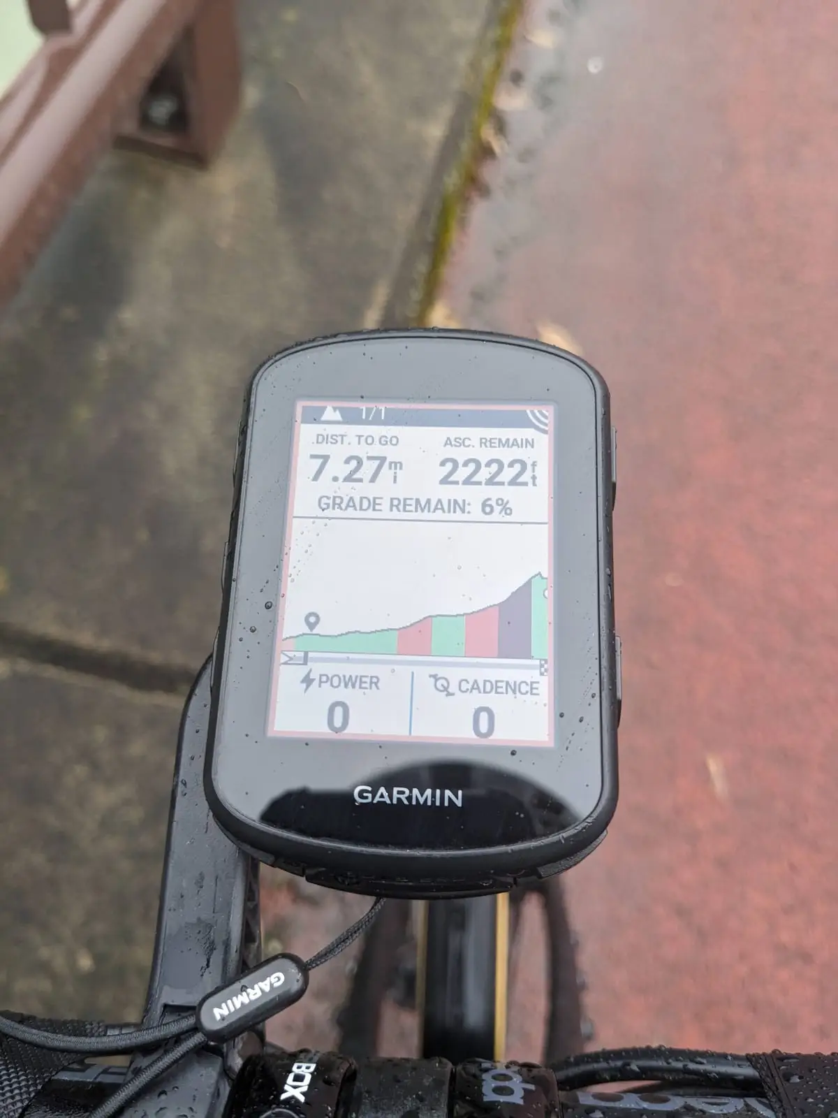 A cycling computer screen showing the elevation profile and remaining ascent of the climb, with power and cadence at zero