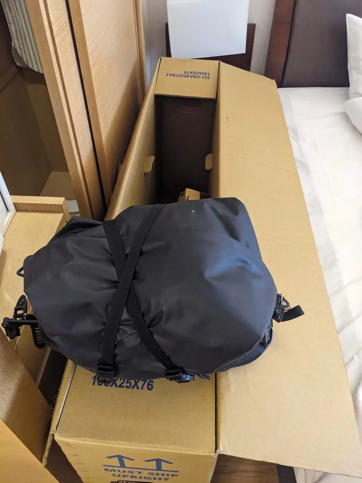 A bike partly packed into a cardboard box with protective wrapping, ready for the flight home