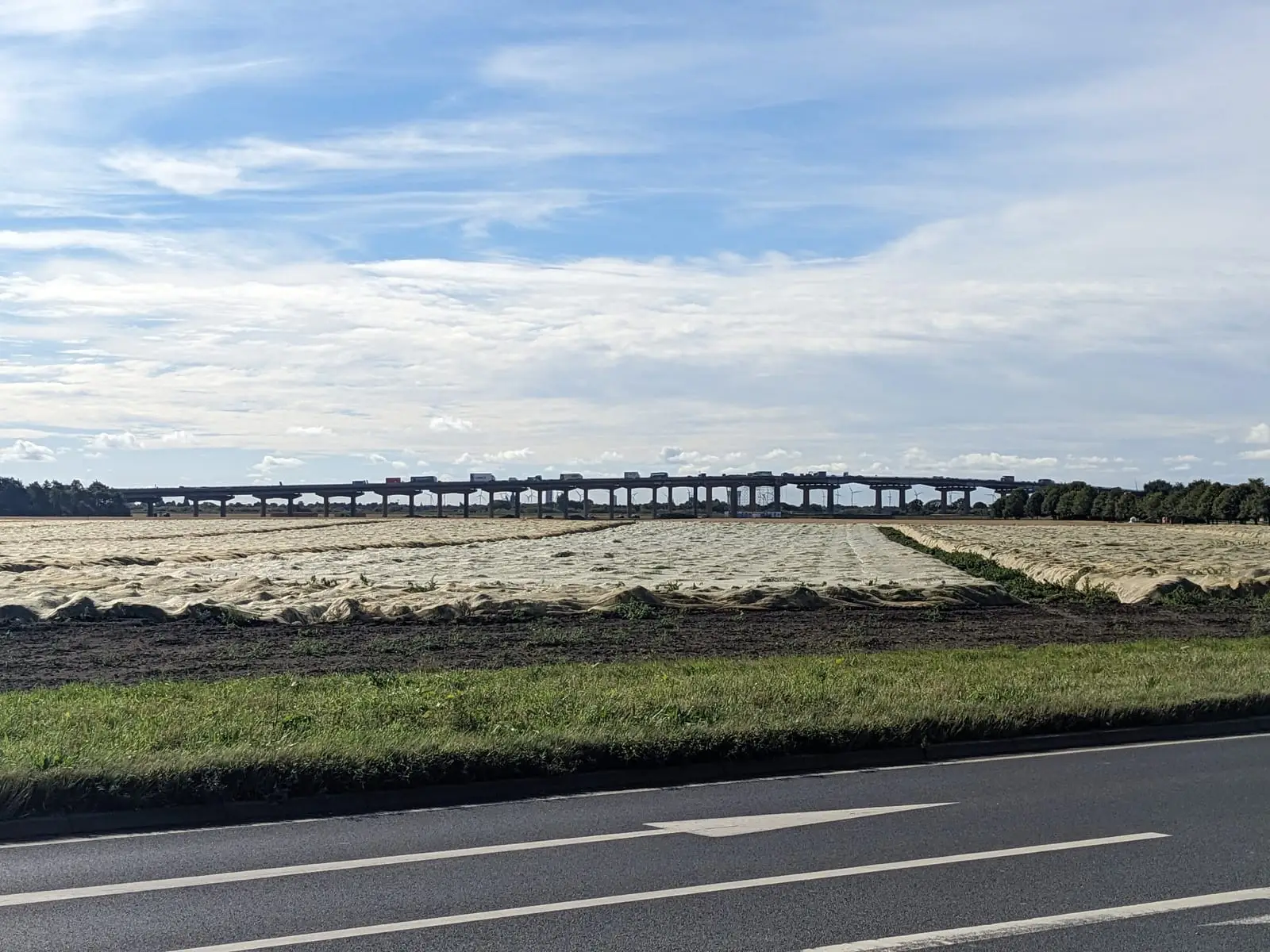 A long bridge crossing the landscape beneath a bright morning sky