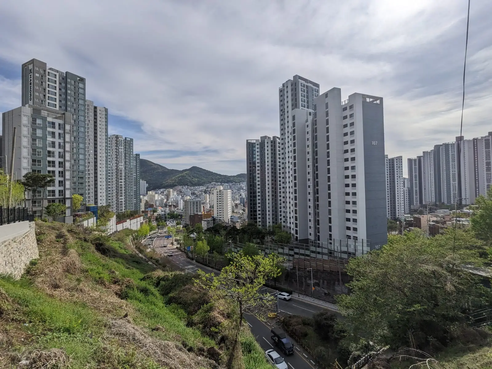 The same Busan apartment towers and hillside view in daylight