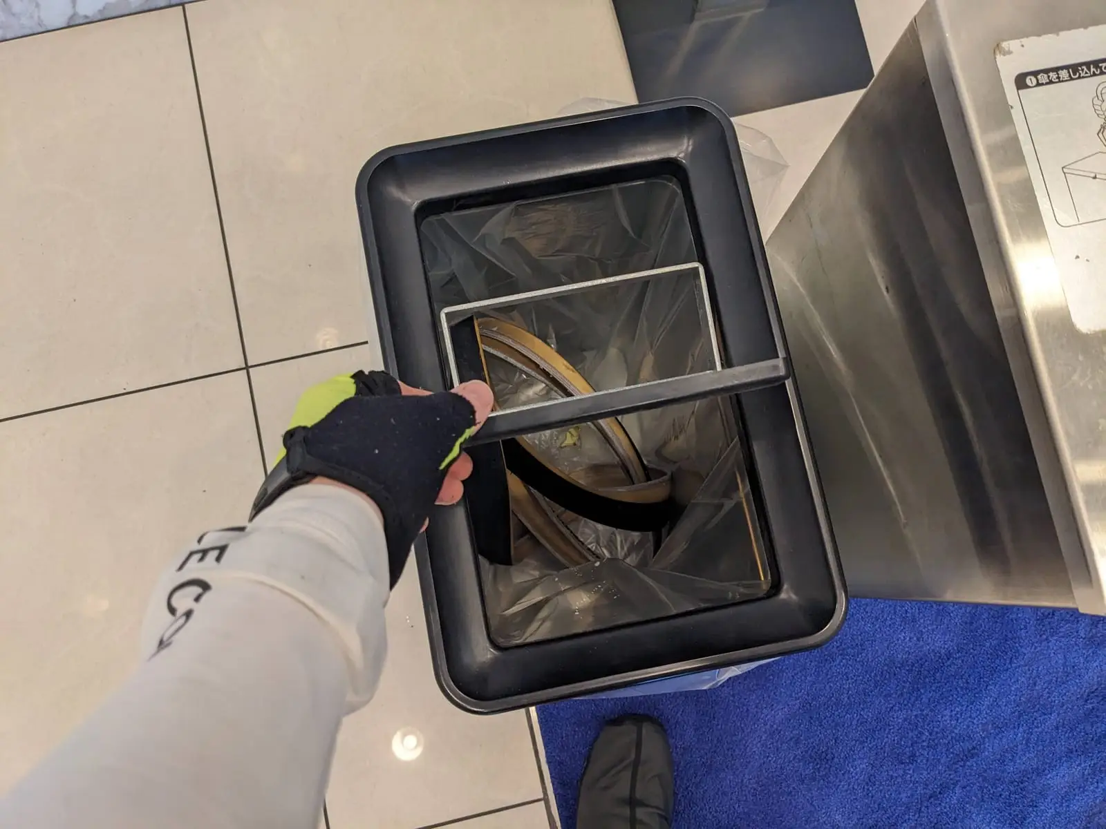 A hand dropping the damaged tyre into a bin