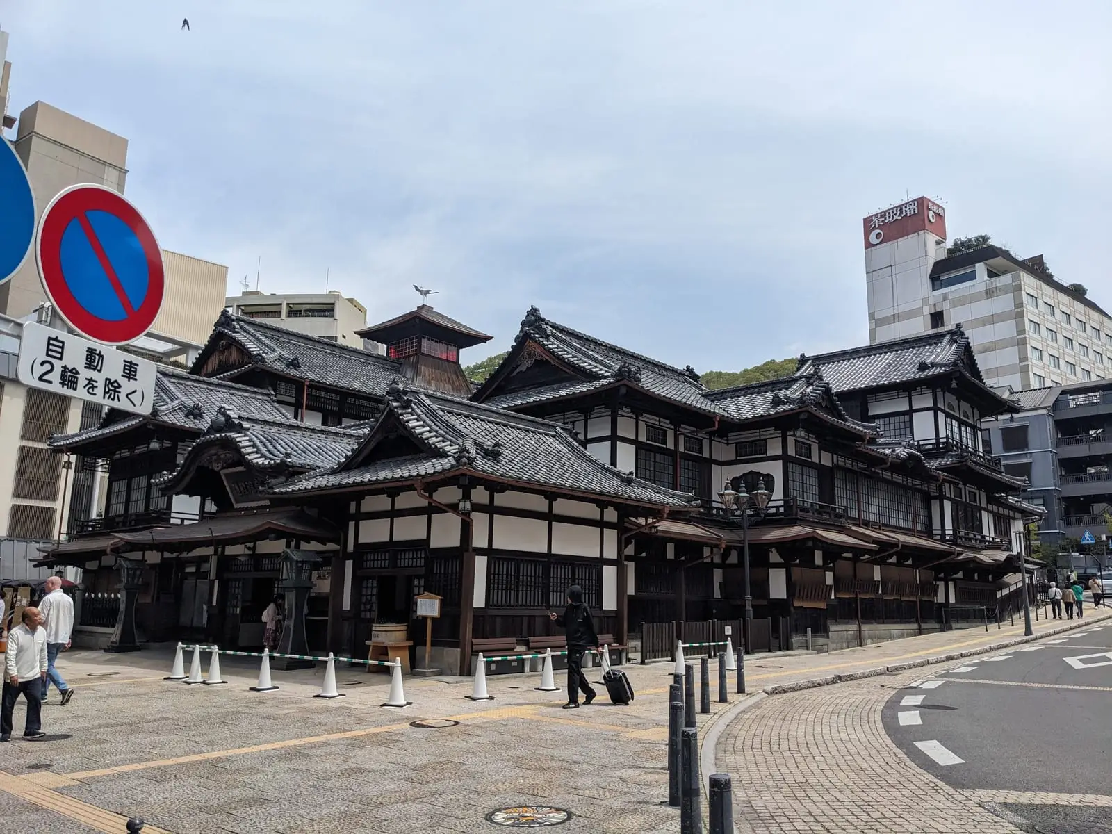 A traditional multi-storey wooden bathhouse building with dark timber and white walls, said to have inspired the bathhouse in the film Spirited Away