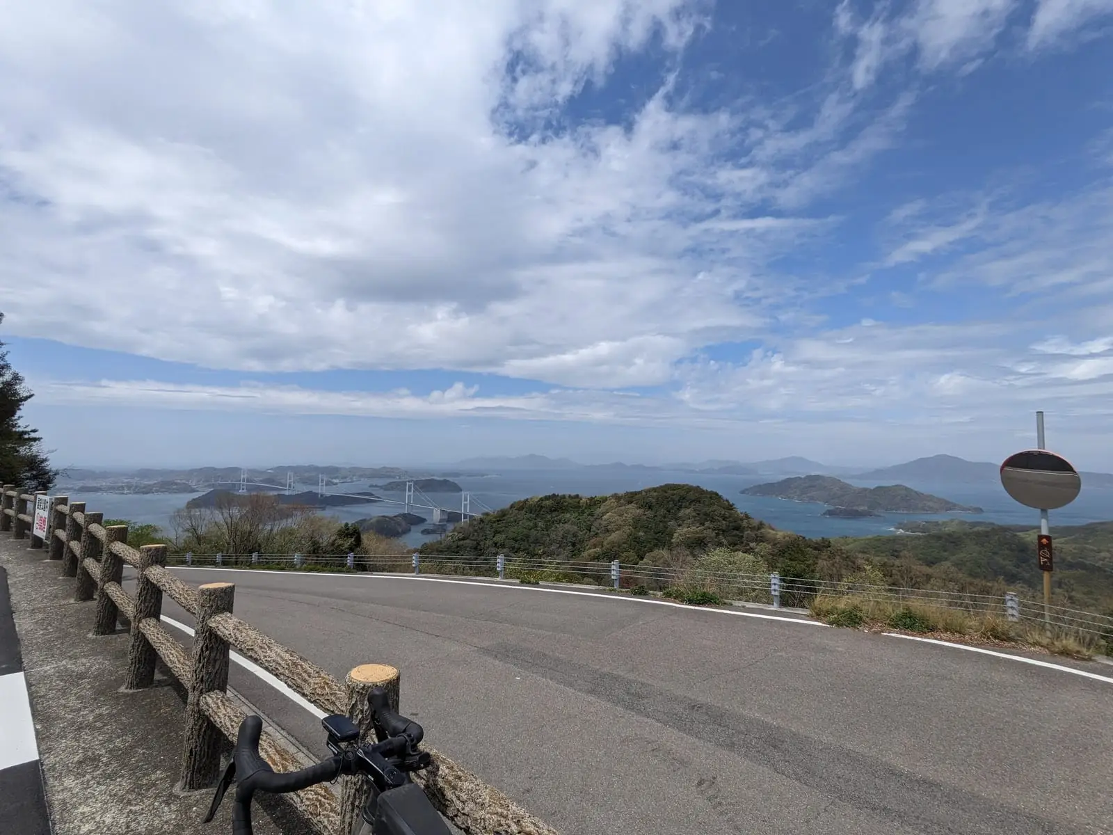 A curving road at a hilltop viewpoint overlooking scattered islands in the Seto Inland Sea