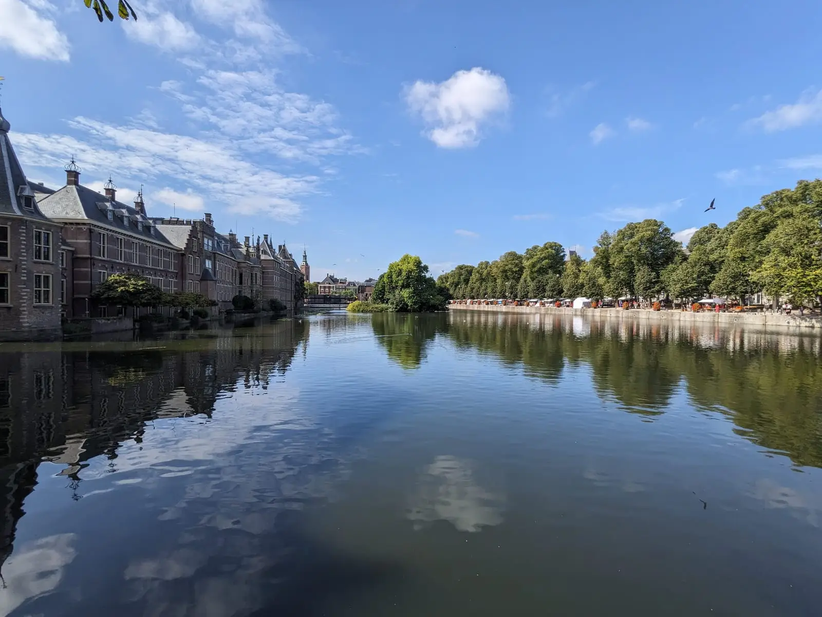 Historic buildings beside the Hofvijver in The Hague under a blue sky
