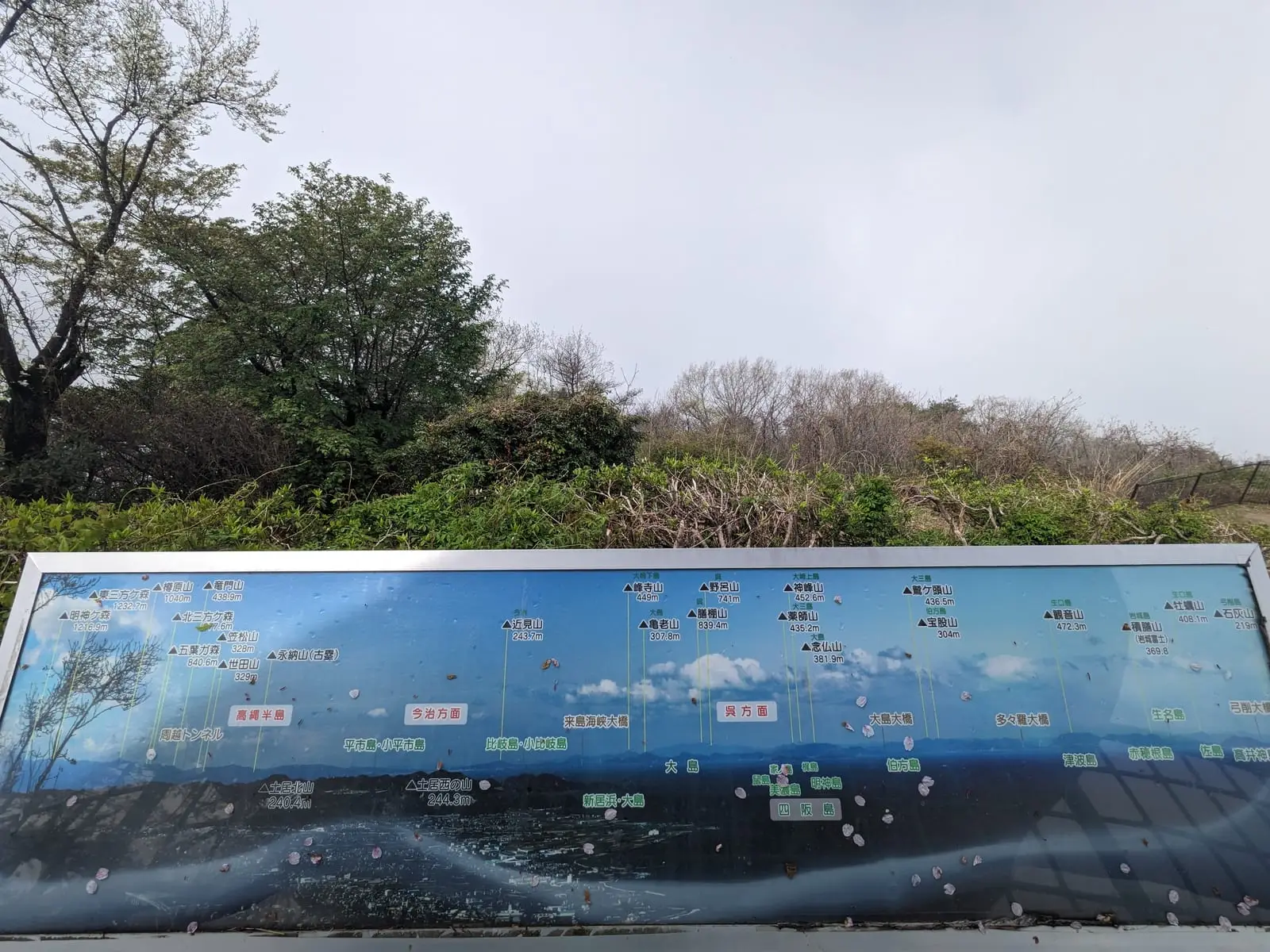 A tourist information board illustrating the mountain view on a clear day, for comparison with the actual fog
