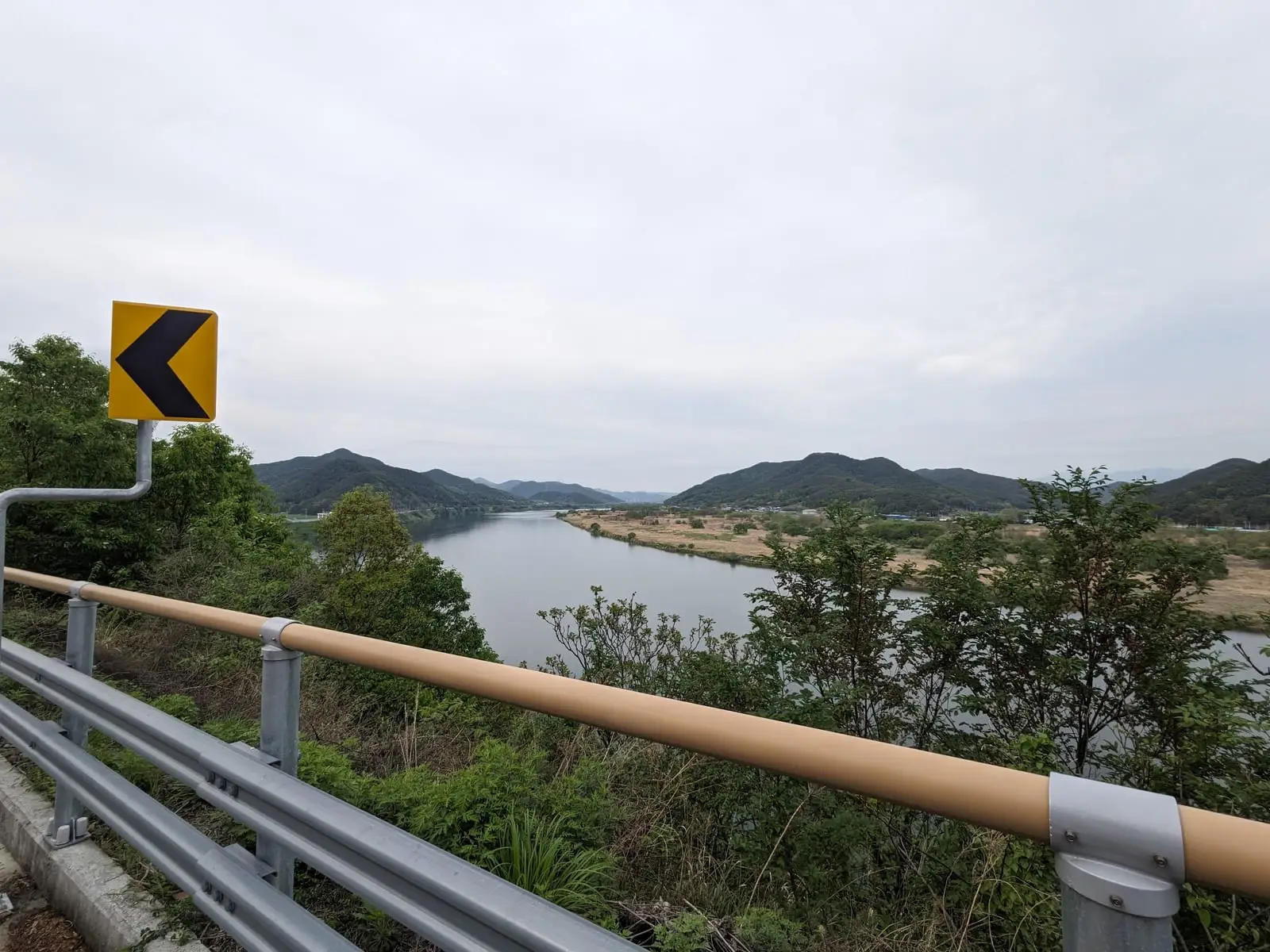 A long straight road crossing a lake, with hills lining the horizon
