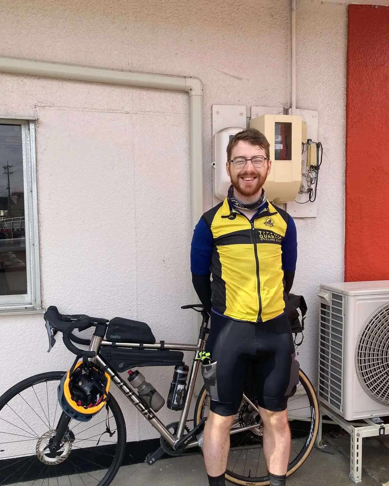 Neil standing indoors at Ichi Coffee Roastery in cycling kit, smiling at the camera, in a photograph taken by the roastery’s owner
