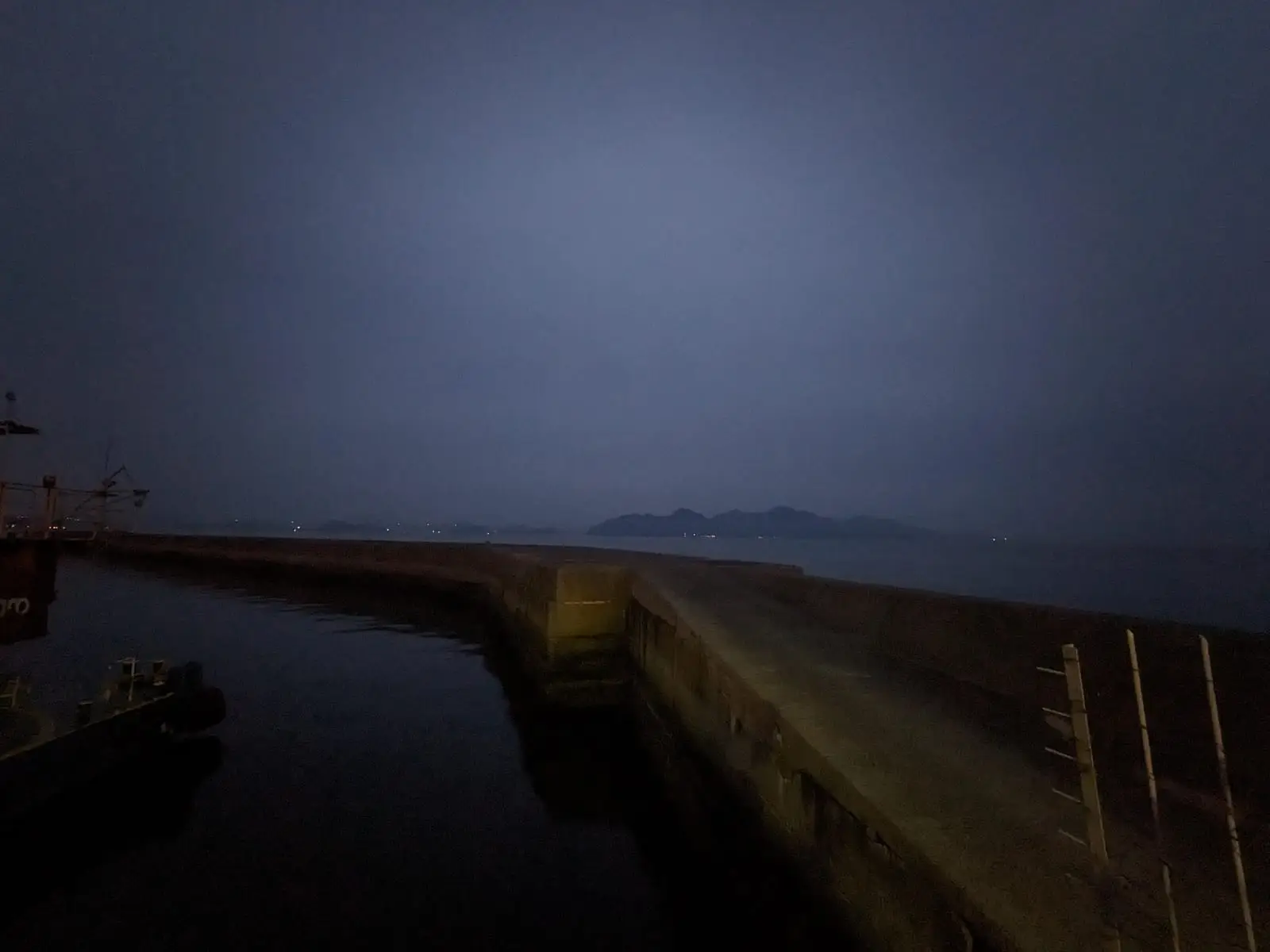 A dark night view over hills and water, with the faint silhouette of the islands to be crossed the next day