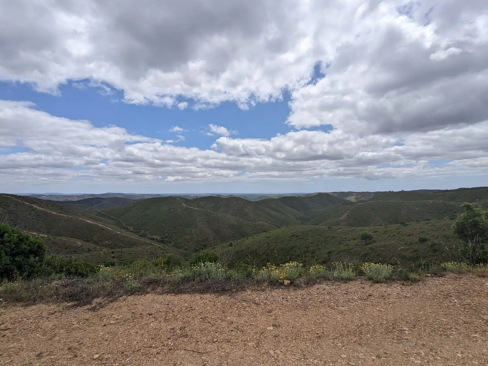 Rolling green hills beneath large clouds in southern Portugal