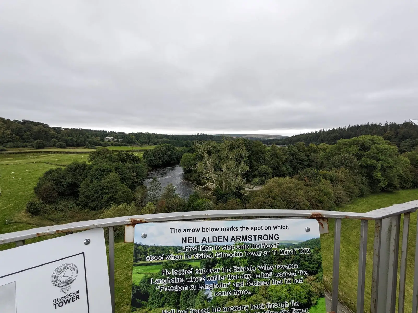 The river valley from Gilnockie Tower beside a sign about Neil Armstrong’s visit