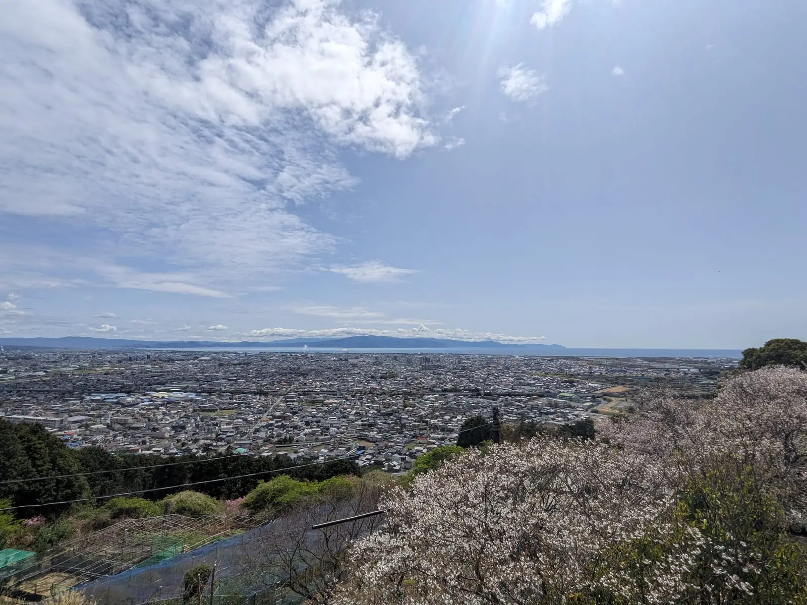 A wide view over a coastal town and hills from the top of the forest hike-a-bike climb