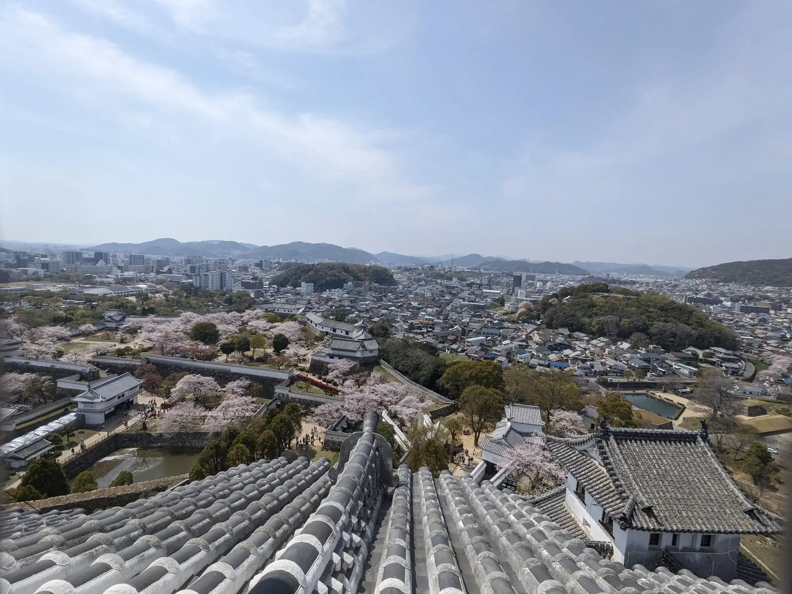 A high view over Himeji’s rooftops and surrounding hills, seen from the castle